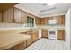Efficient kitchen with white appliances, tile flooring, and ample cabinet space at 36208 Micro Racetrack Rd, Fruitland Park, FL 34731