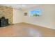 Bright living room featuring wood-look floors, brick fireplace, and a large window with views of trees at 36208 Micro Racetrack Rd, Fruitland Park, FL 34731