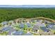 Stunning aerial view of modern homes nestled beside a serene pond and lush green forest at 4296 Mirror Ct, Clermont, FL 34714
