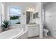 Bright bathroom featuring a soaking tub, granite vanity, and separate toilet room for added privacy at 4296 Mirror Ct, Clermont, FL 34714