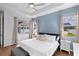 A light blue accent wall enhances this bedroom, with a tray ceiling and three windows at 4296 Mirror Ct, Clermont, FL 34714