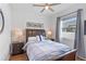 This is a well-lit bedroom featuring a ceiling fan and a bed with nightstands on either side at 4296 Mirror Ct, Clermont, FL 34714