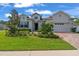 Inviting home featuring lush landscaping, a brick driveway, and a convenient attached two-car garage at 4296 Mirror Ct, Clermont, FL 34714