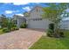 Attractive home featuring a brick driveway, well-maintained landscaping, and an attached two-car garage in a quiet neighborhood at 4296 Mirror Ct, Clermont, FL 34714