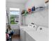 Functional laundry room with a sink, modern washer and dryer, and ample storage space above at 4296 Mirror Ct, Clermont, FL 34714