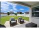 Comfortable covered patio with seating area and view of the fenced backyard at 4296 Mirror Ct, Clermont, FL 34714