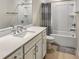 A bright bathroom boasts a white quartz countertop and a shower-tub combination at 4336 Foggy Oak Ln, Sanford, FL 32773
