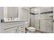 A modern bathroom with a sleek white vanity, toilet and a glass-enclosed shower featuring stylish tile accents at 4336 Foggy Oak Ln, Sanford, FL 32773