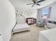 Cozy Bedroom features a crib, single bed, chair, and playful wall decals, perfect for a young  at 4336 Foggy Oak Ln, Sanford, FL 32773