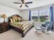 This bedroom features a ceiling fan, a wooden dresser, and a cozy reading chair with ottoman at 4336 Foggy Oak Ln, Sanford, FL 32773