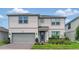 Charming two-story home with a manicured lawn, beautiful landscaping and gray siding at 4336 Foggy Oak Ln, Sanford, FL 32773
