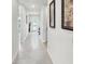 Hallway with tile flooring leading to a glass door and featuring decorative artwork at 4336 Foggy Oak Ln, Sanford, FL 32773