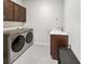A well-equipped laundry room with modern Samsung washer and dryer, along with a sink and storage cabinets at 4336 Foggy Oak Ln, Sanford, FL 32773