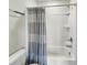 A white shower-tub combination is fitted with a patterned shower curtain and features chrome fixtures at 4336 Foggy Oak Ln, Sanford, FL 32773