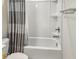 A white shower-tub combination is fitted with a patterned shower curtain and features chrome fixtures at 4336 Foggy Oak Ln, Sanford, FL 32773