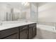 Bathroom with a white countertop, dark cabinets, soaking tub, walk-in shower, and ample natural light at 4350 Verde Valley Ln, Kissimmee, FL 34746
