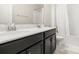 Bathroom with a double sink vanity, white countertops, dark cabinets, and a shower-tub combination at 4350 Verde Valley Ln, Kissimmee, FL 34746