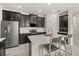 Modern kitchen features a stainless steel refrigerator, dark wood cabinets, and a large island with a white countertop at 4350 Verde Valley Ln, Kissimmee, FL 34746