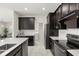 The kitchen has stainless appliances, dark cabinets, and a large center island with white countertop and tile floors at 4350 Verde Valley Ln, Kissimmee, FL 34746