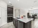 Open kitchen with large island, stainless steel appliances, dark cabinets, and access to living and dining areas at 4350 Verde Valley Ln, Kissimmee, FL 34746