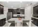 Modern kitchen with stainless steel appliances, an island with seating, and dark cabinetry at 4350 Verde Valley Ln, Kissimmee, FL 34746