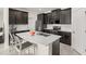 Modern kitchen with stainless steel appliances, an island with seating, and dark cabinetry at 4350 Verde Valley Ln, Kissimmee, FL 34746