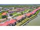 Condominiums with red tile roofs feature waterfront views, lush landscaping, and convenient parking for residents and visitors at 446 Bouchelle Dr # 103, New Smyrna Beach, FL 32169