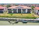 Aerial view of condominium building with terracotta roof, dock, and lush landscaping at 446 Bouchelle Dr # 103, New Smyrna Beach, FL 32169