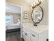 Bright bathroom with white vanity, round mirror, and access to bedroom at 446 Bouchelle Dr # 103, New Smyrna Beach, FL 32169