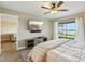 Cozy bedroom featuring a ceiling fan, tv, and water view at 446 Bouchelle Dr # 103, New Smyrna Beach, FL 32169