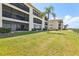 The three-story condominium building with screened balconies and manicured green lawn at 446 Bouchelle Dr # 103, New Smyrna Beach, FL 32169