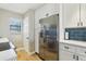 Well-lit kitchen with stainless steel refrigerator and blue backsplash at 446 Bouchelle Dr # 103, New Smyrna Beach, FL 32169