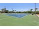 Outdoor tennis courts provide an active recreational amenity for the community, with beautiful landscaping and sky at 446 Bouchelle Dr # 103, New Smyrna Beach, FL 32169