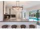 Modern kitchen with stainless steel appliances, island seating, and view of the outdoor pool at 5100 La Croix Ave, Belle Isle, FL 32812