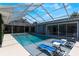 The screened-in pool offers a relaxing spot with lounge chairs and bright blue sky above at 5100 La Croix Ave, Belle Isle, FL 32812