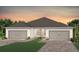 Charming single-story home featuring a two-car garage and lush landscaping, creating inviting curb appeal at 5156 Gardenrow Dr, St Cloud, FL 34772