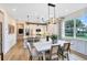 Open concept kitchen and dining room featuring modern lighting, white cabinetry, and stainless steel appliances at 5156 Gardenrow Dr, St Cloud, FL 34772