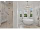 Bright bathroom with a soaking tub, a frameless glass shower, and designer fixtures at 5550 Osprey Isle Ln, Orlando, FL 32819