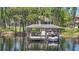 Picturesque wooden boat dock with a boat, set against a serene waterfront and lush landscaping at 5550 Osprey Isle Ln, Orlando, FL 32819