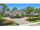 Elegant home featuring a brick driveway, mature palms, and perfectly manicured landscaping at 5550 Osprey Isle Ln, Orlando, FL 32819