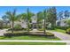 Stunning two-story home with lush landscaping, mature palms, and a circular driveway at 5550 Osprey Isle Ln, Orlando, FL 32819