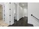 Hallway with dark hardwood floors, white walls, and multiple doors leading to various rooms at 5550 Osprey Isle Ln, Orlando, FL 32819