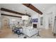 Bright living room featuring high ceilings with wooden beams, tile floors, and an open floor plan leading to the kitchen at 5550 Osprey Isle Ln, Orlando, FL 32819