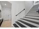 Modern staircase features black treads, white risers, and a sleek black handrail at 5550 Osprey Isle Ln, Orlando, FL 32819