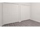 Bright bedroom featuring two large reach-in closets, with white painted doors and grey vinyl floors at 5953 Westgate Dr # 1823, Orlando, FL 32835