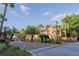 Gated community entrance featuring lush landscaping, palm trees, and well-maintained residences at 5953 Westgate Dr # 1823, Orlando, FL 32835