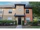 Townhouse exterior featuring a covered entry, well-manicured bushes and a symmetrical design at 5953 Westgate Dr # 1823, Orlando, FL 32835