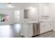 Open-concept kitchen with an island, stainless steel dishwasher, and modern white cabinets at 5953 Westgate Dr # 1823, Orlando, FL 32835