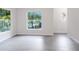 Bright living room featuring grey vinyl floors and two large windows with outside views at 5953 Westgate Dr # 1823, Orlando, FL 32835