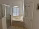 Bright bathroom featuring a soaking tub, separate shower, and window for natural light at 708 Pincon Ln, Kissimmee, FL 34759